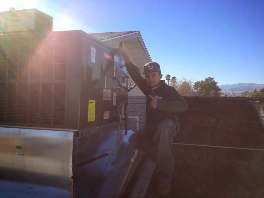 HVAC technician performing Heat Pump Repair on a rooftop unit in Middletown